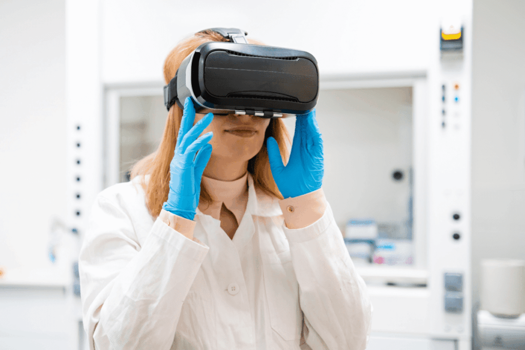 A health professional wearing blue gloves and a white coat uses a virtual reality headset while standing in a modern laboratory.