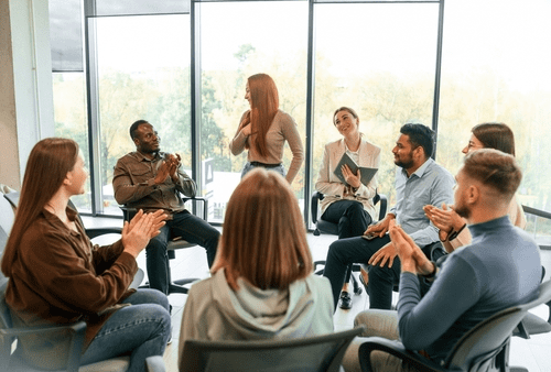 A group of stakeholders sits in an office, discussing the meeting’s topic. 